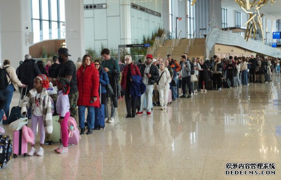 3月27日，乘客在美国纽约拉瓜迪亚机场排队等待安检。新华社记者张凤国摄