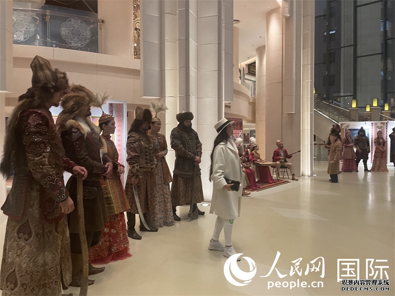 观众与展示哈萨克斯坦民族服装的模特合影。人民网记者 曲颂摄