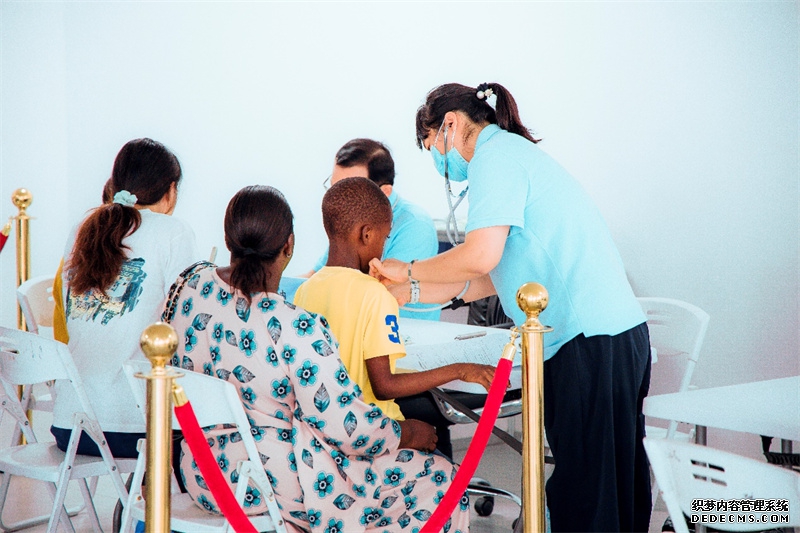 援外医疗队员对当地儿童患者问诊。坦桑尼亚东非商贸物流中心供图