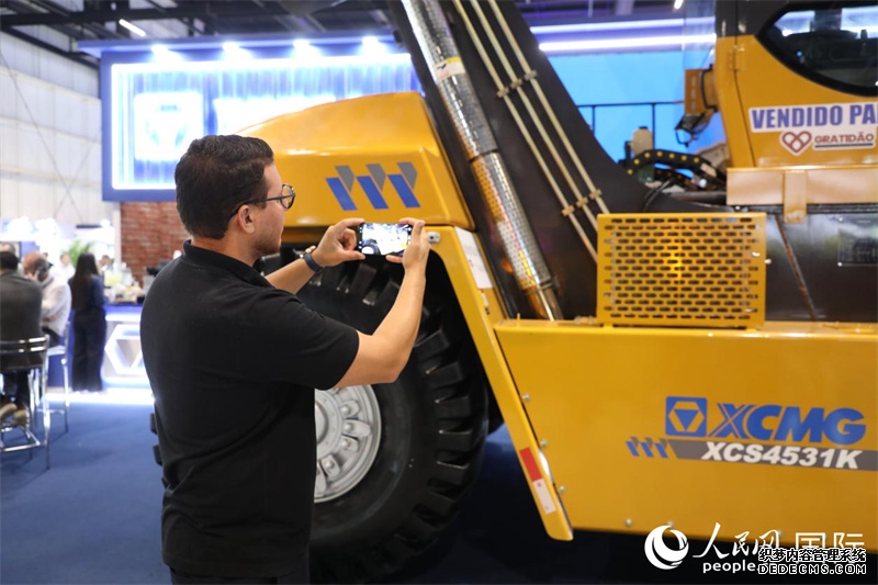 展会现场，一名参观者拍摄徐工集团展出的装备。人民网记者 陈一鸣摄